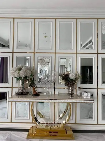 Luxurious interior with elegant console table and mirrored wall panels in a sophisticated living space.