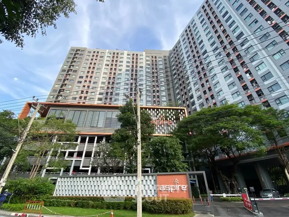 Modern high-rise residential building with lush greenery and contemporary design.