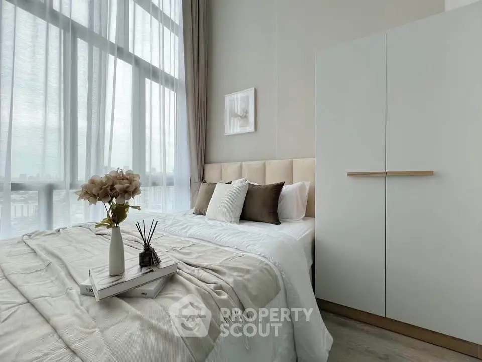 Elegant bedroom with large window and modern decor in high-rise apartment