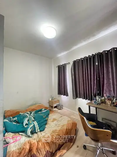 Cozy bedroom with natural light and modern furnishings, perfect for relaxation and productivity.