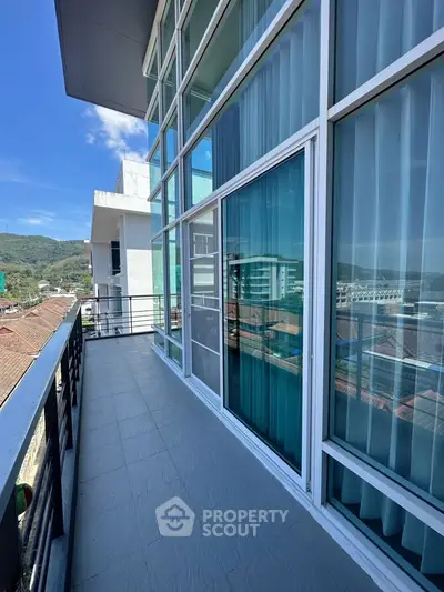 Spacious balcony with stunning city and mountain views, perfect for relaxation and entertainment.