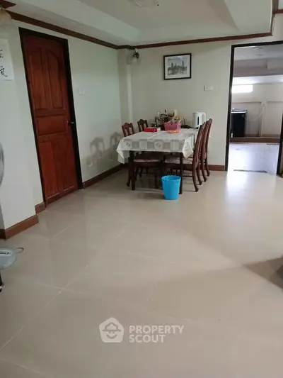 Spacious dining area with elegant wooden furniture and tiled flooring