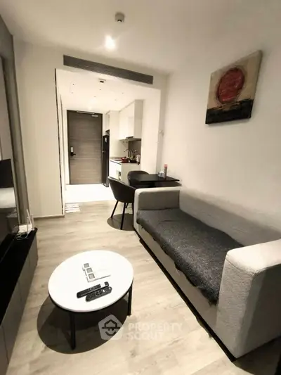 Modern living room with sleek furniture and open kitchen layout in a stylish apartment.