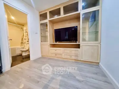 Spacious living room with built-in wooden entertainment unit and modern flooring