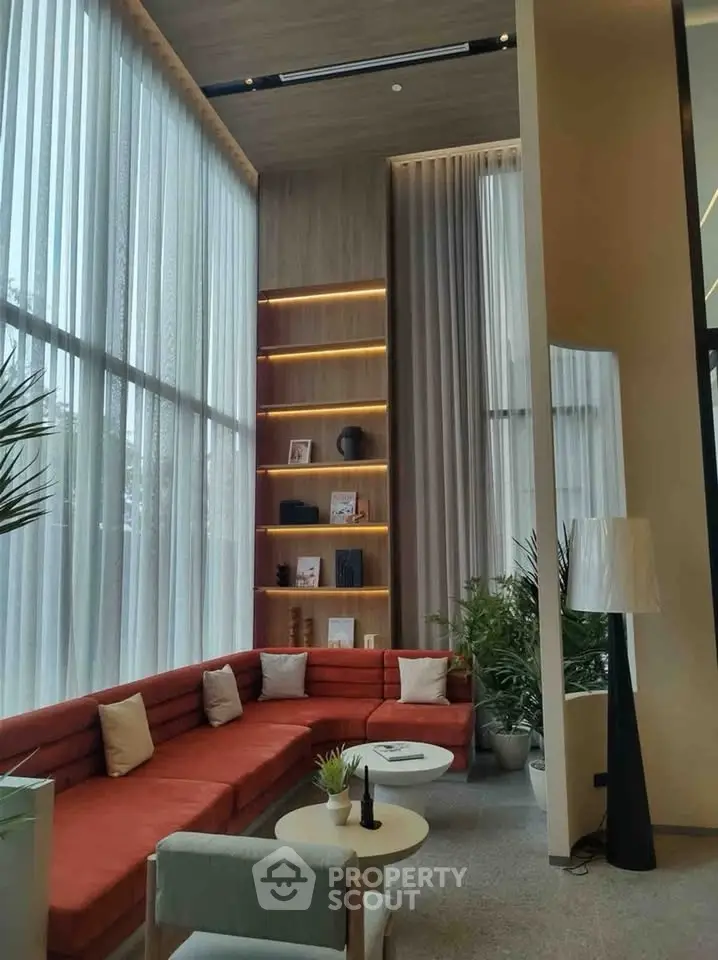 Luxurious modern living room with high ceilings, elegant decor, and large windows for natural light.