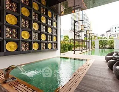 Luxurious pool area with artistic wall decor in modern urban setting.