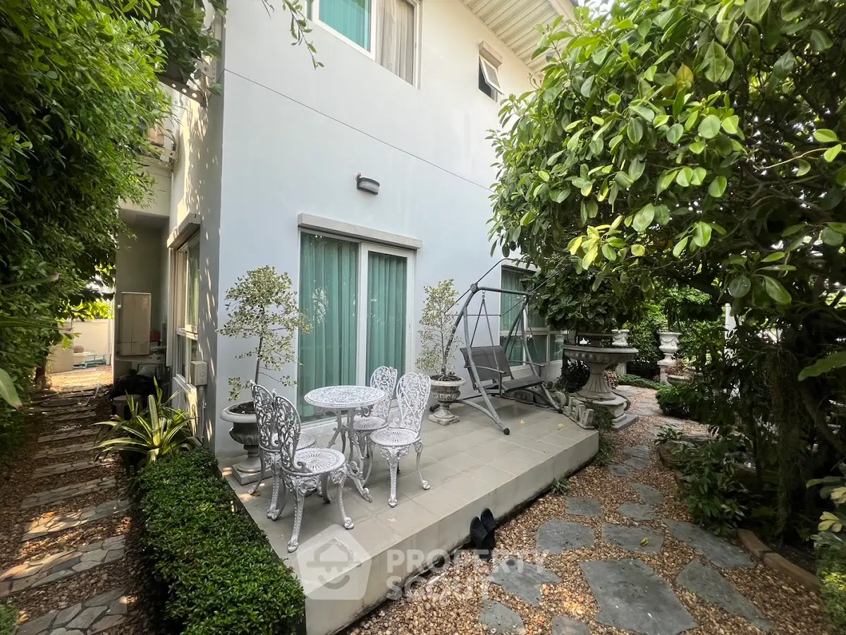 Charming garden patio with elegant outdoor furniture and lush greenery