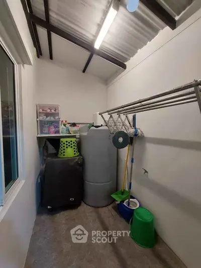 Compact storage room with cleaning supplies and laundry equipment, ideal for organized home maintenance.