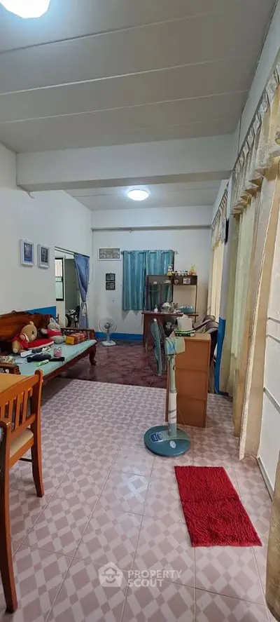 Cozy living room with natural light, featuring a comfortable seating area and charming decor.