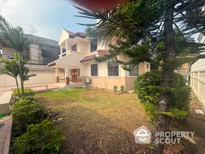 Charming two-story house with spacious garden and lush greenery, perfect for family living.