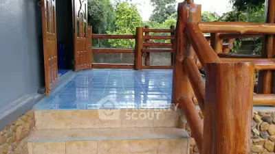 Charming rustic entrance with wooden railings and tiled steps in a serene setting.