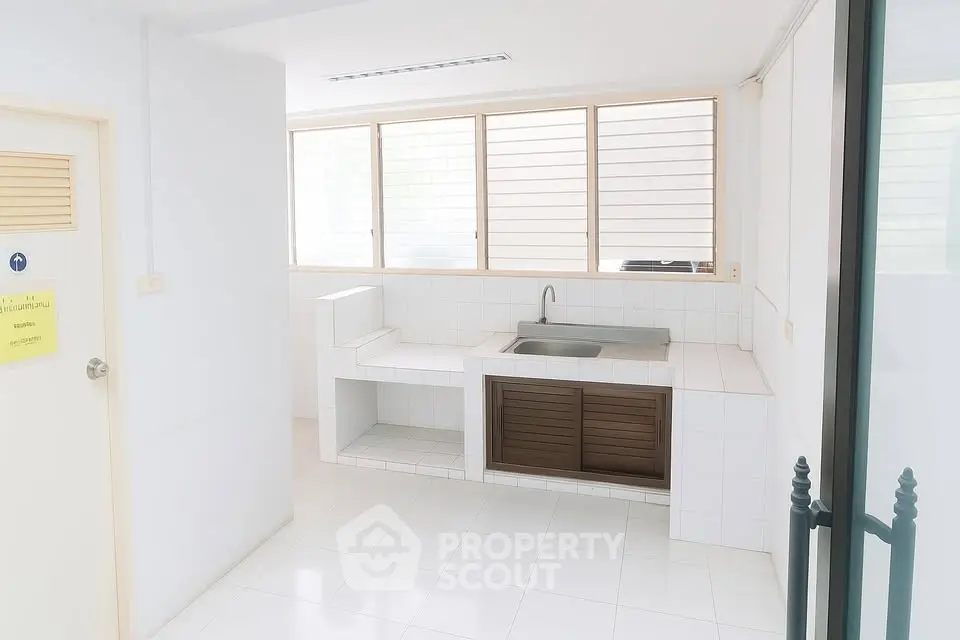 Bright minimalist kitchen with large windows and sleek white tiles