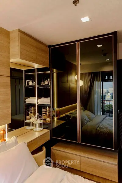 Modern bedroom with sleek mirrored wardrobe and cozy lighting
