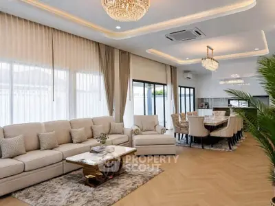 Luxurious open-plan living and dining area with elegant chandeliers and plush furnishings.