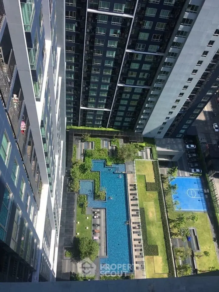 Stunning aerial view of modern apartment complex with pool and sports court
