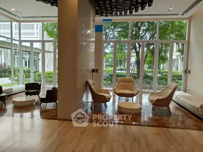 Luxurious modern living room with elegant seating and large windows overlooking greenery.