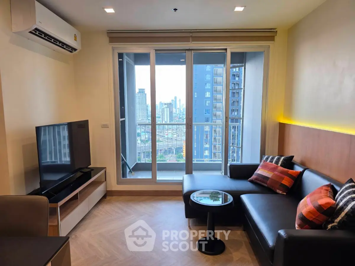 Modern living room with city view, featuring sleek furniture and large windows for natural light.