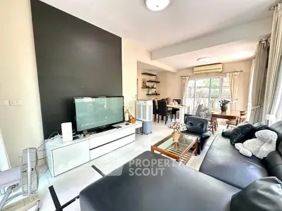 Spacious modern living room with sleek black accent wall and cozy seating area.