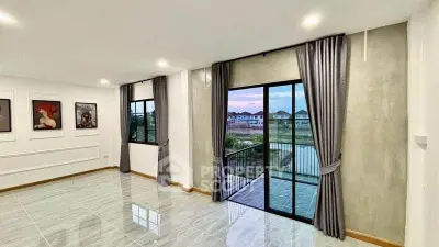 Spacious living room with large windows and balcony offering serene views.