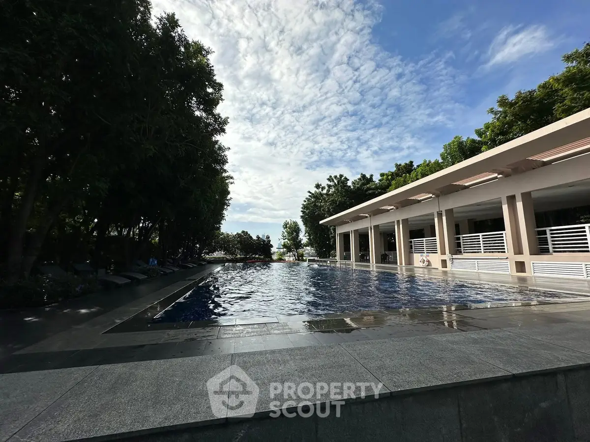 Luxurious outdoor pool area with modern design and lush greenery, perfect for relaxation and leisure.