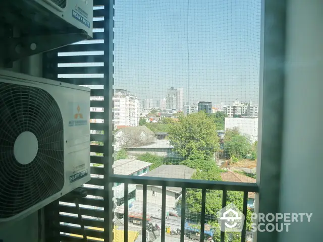 City view from balcony with air conditioning unit and urban skyline