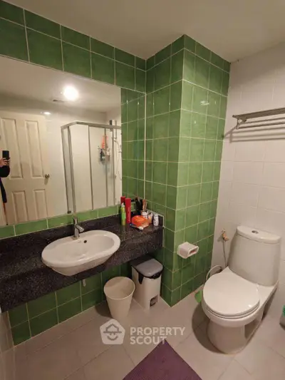 Modern bathroom with green tiles and sleek fixtures