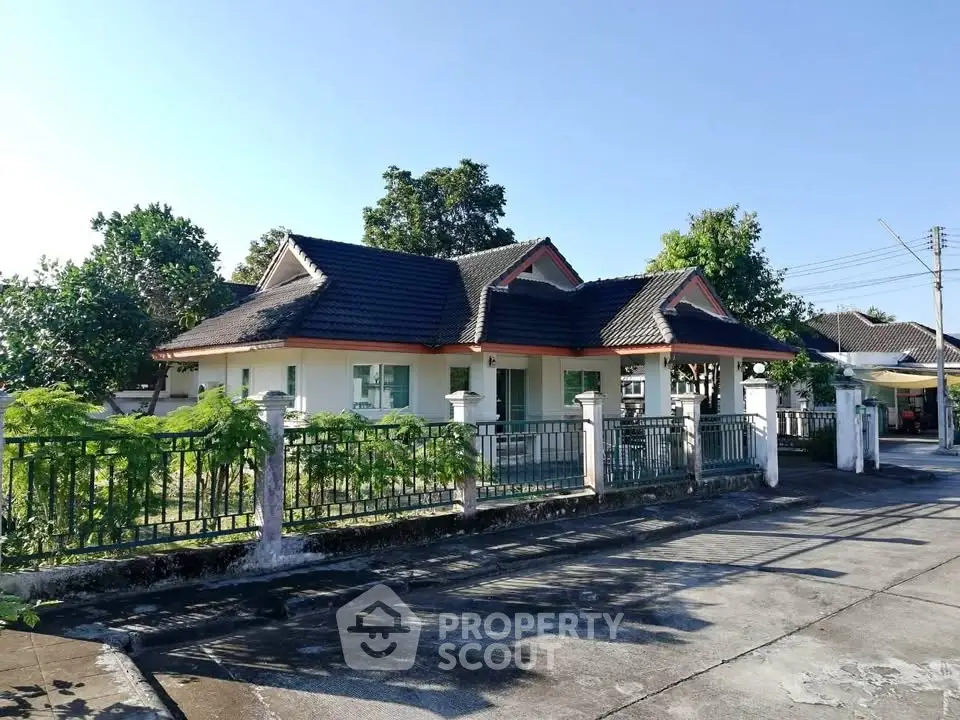 Charming single-story house with a spacious garden and classic roof design in a serene neighborhood.