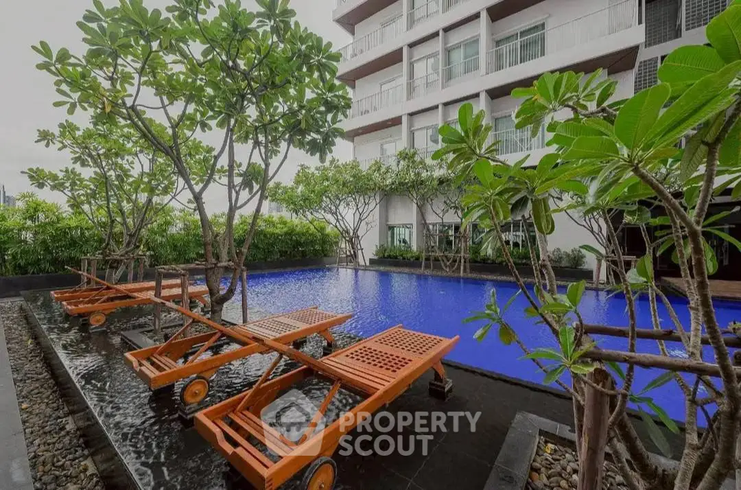 Luxurious apartment building with serene poolside and lush greenery, perfect for relaxation and leisure.
