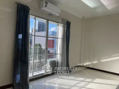 Bright empty room with large window and air conditioning unit, ideal for customization.