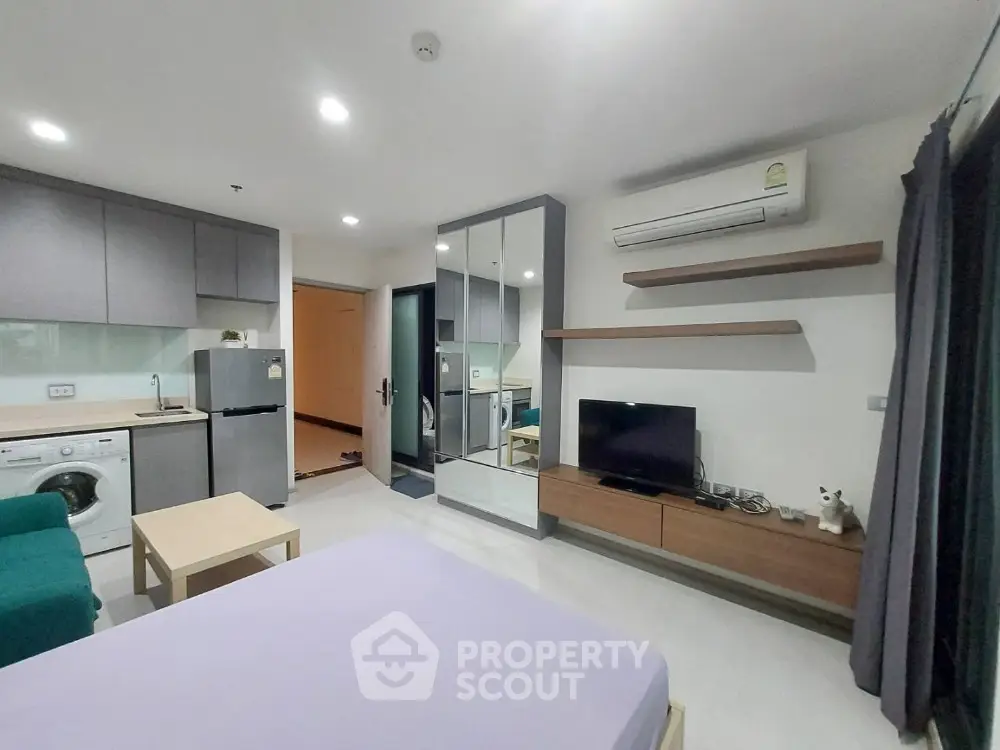 Modern studio apartment with open layout, featuring a cozy living area, compact kitchen, and stylish decor.
