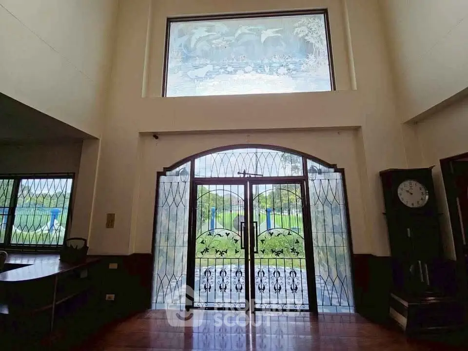 Elegant entrance with decorative glass doors and high ceiling, perfect for a luxurious home.