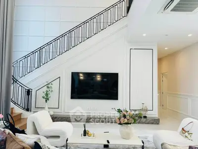 Luxurious modern living room with elegant staircase and large TV, perfect for stylish entertaining.
