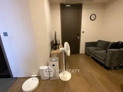 Cozy living room with modern furniture and appliances, featuring a sleek sofa and stylish fan.