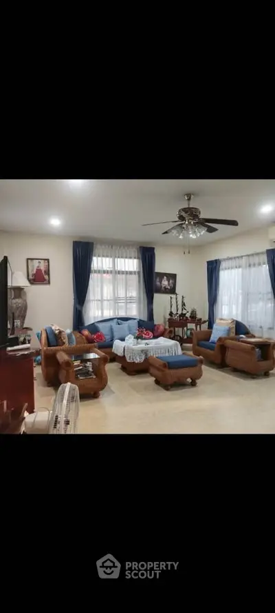 Spacious living room with elegant wicker furniture and ceiling fan