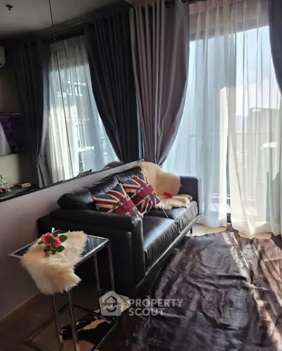 Chic living room with leather sofa, floor-to-ceiling windows, and stylish decor