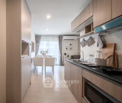 Modern kitchen with sleek cabinetry and dining area in open layout apartment