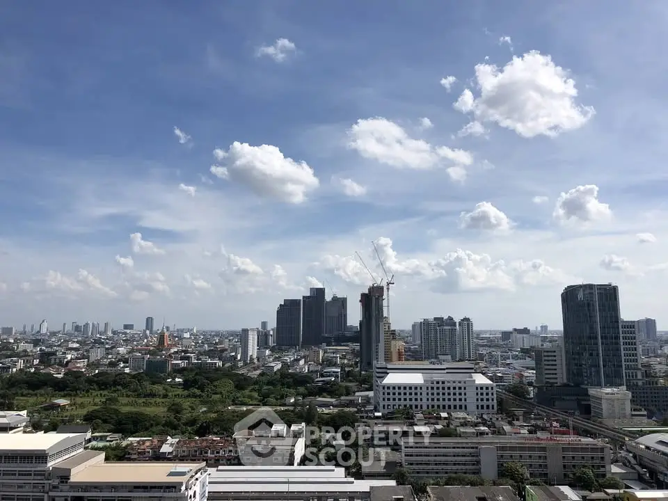 Stunning cityscape view with modern skyscrapers and lush greenery under a clear blue sky.