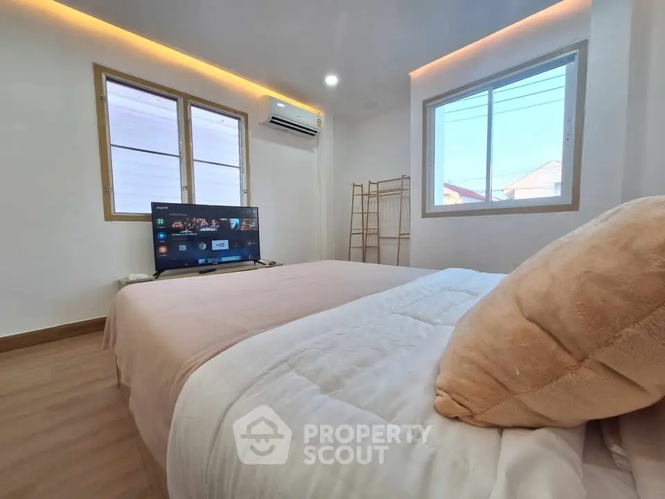 Cozy bedroom with modern TV setup and natural light