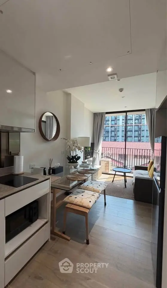 Modern living room with open kitchen and balcony view in urban apartment