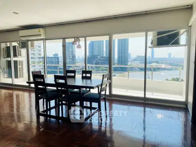 Spacious dining area with stunning city and river views, featuring elegant wooden flooring and modern furniture.