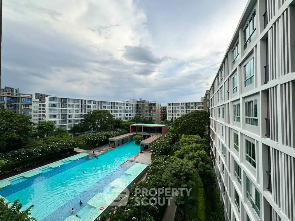 Luxurious residential complex with a stunning pool and lush greenery, offering a serene urban living experience.