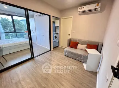 Modern apartment with cozy living area and bedroom, featuring a washing machine and air conditioning.