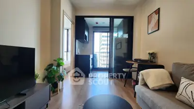 Modern living room with balcony view, stylish decor, and open layout in urban apartment.