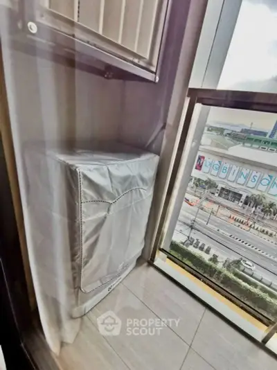 Modern apartment balcony with city view and covered air conditioning unit.