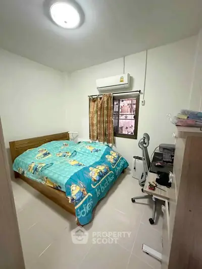 Cozy bedroom with air conditioning and vibrant bedding in a compact space.