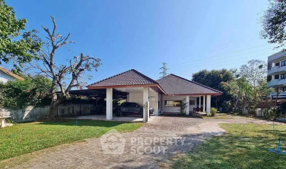 Charming single-story house with spacious driveway and lush garden.