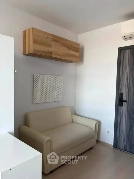 Cozy living room with modern sofa and wall-mounted storage in a minimalist design.