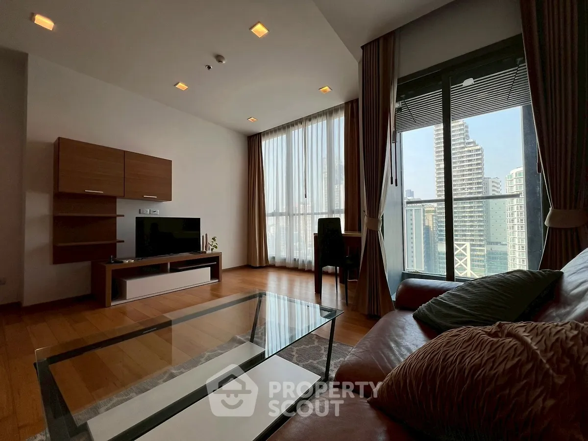 Spacious living room with city view, modern furniture, and floor-to-ceiling windows.