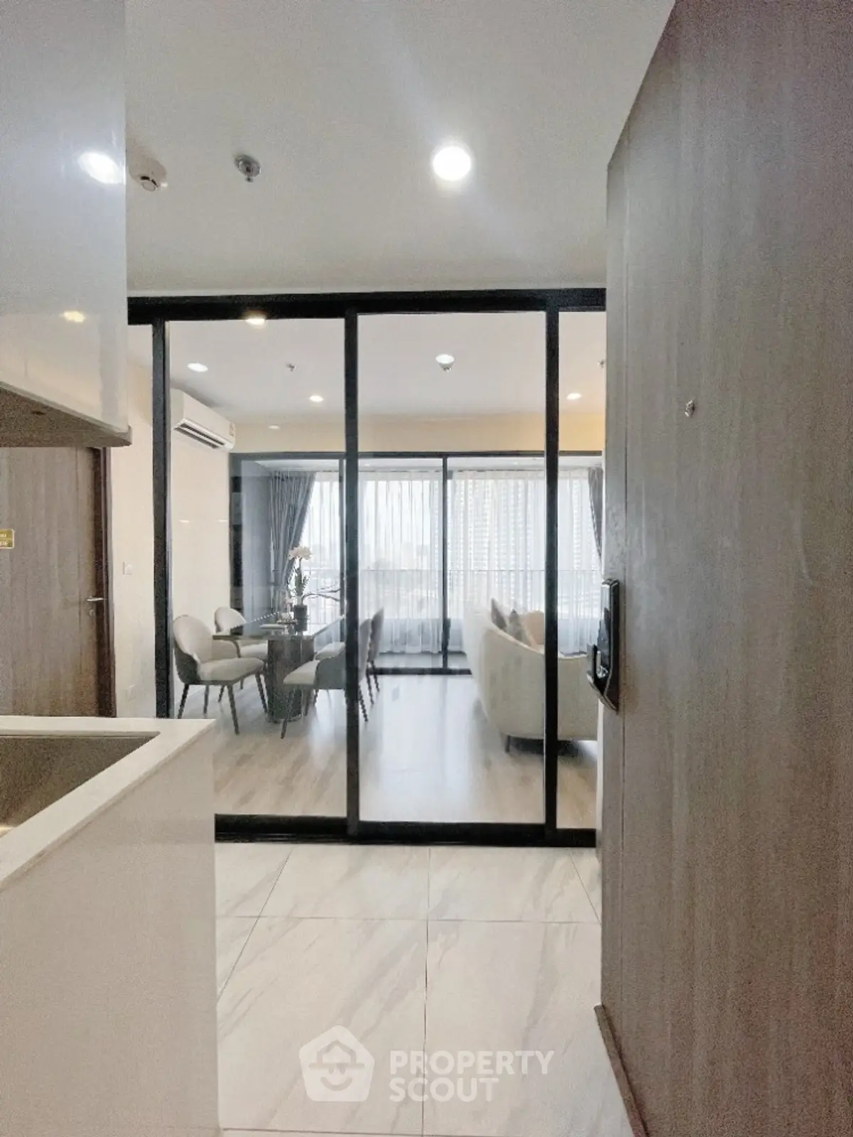 Modern open-plan living room with glass partition and elegant decor