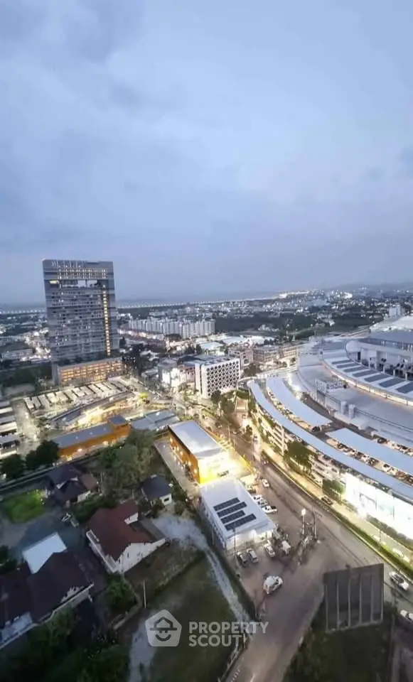 Stunning aerial view of urban landscape with modern buildings and vibrant city lights at dusk.